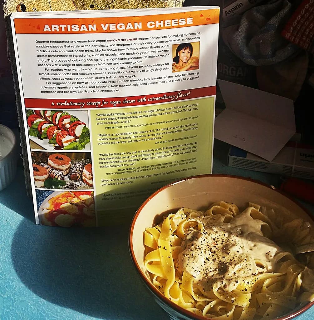 A plate of fettuccine coated in silky cashew cream sauce with cracked black pepper and lemon zest