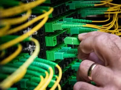 A technician walking between illuminated server racks in a large cloud data center