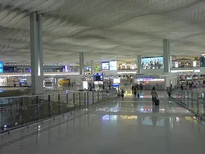 A traveler at a European airport biometric border control kiosk with a departure board in the background