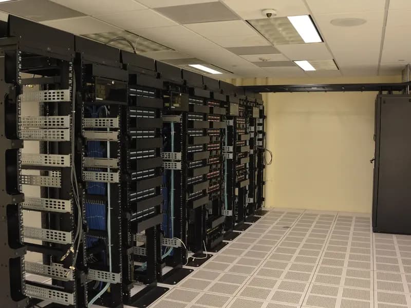 Rows of server racks in a data centre, lit from within, of the kind that trains and runs large AI models