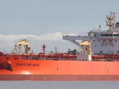 A loaded crude oil tanker alongside, its red hull low in the water and the accommodation block and bridge visible aft
