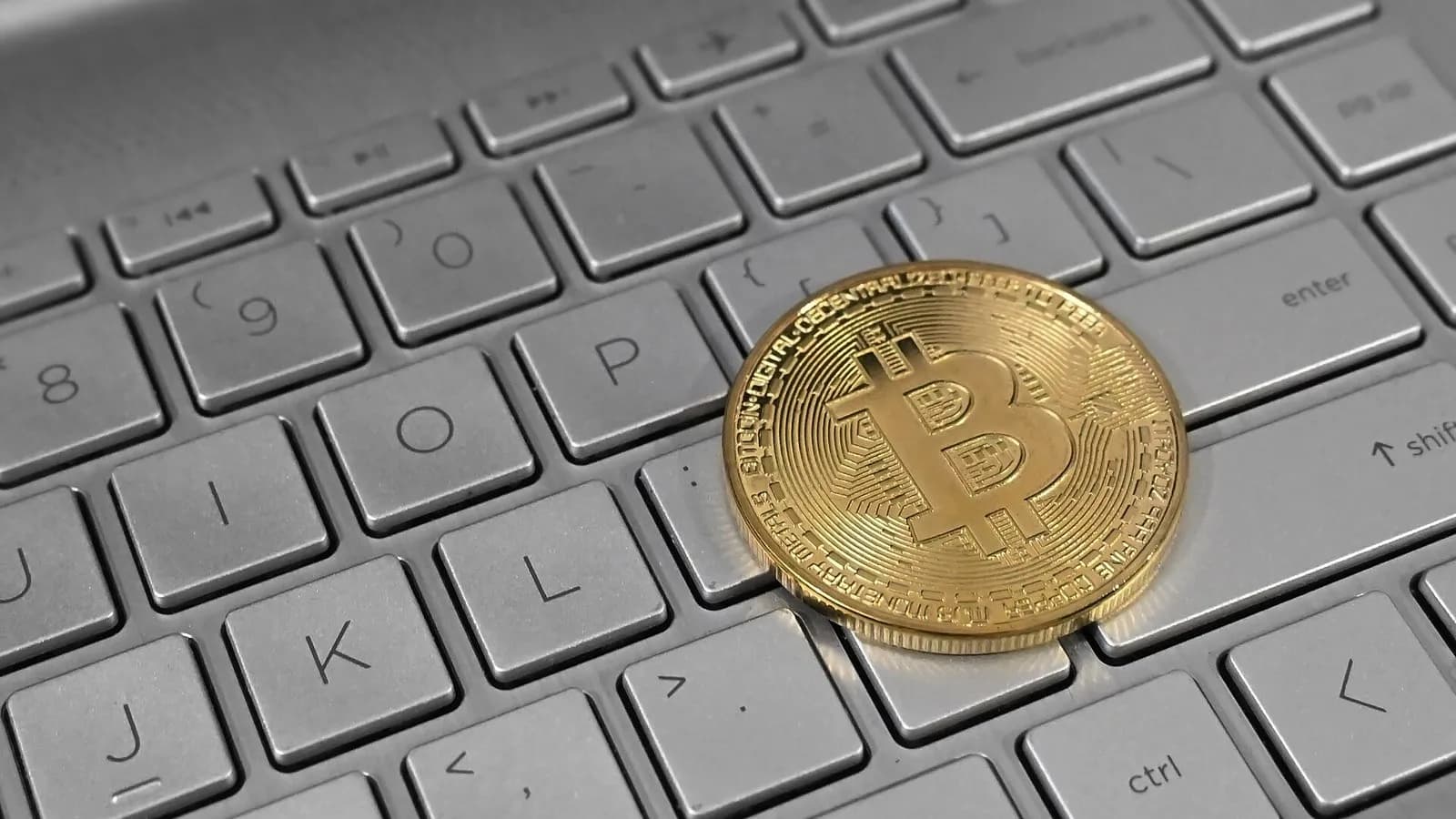 A gold-coloured physical bitcoin coin lying on a white laptop keyboard, photographed in February 2023, a file photograph illustrative of bitcoin and not of this week's price moves