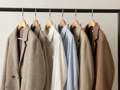 A short rail of well-made garments in neutral tones
