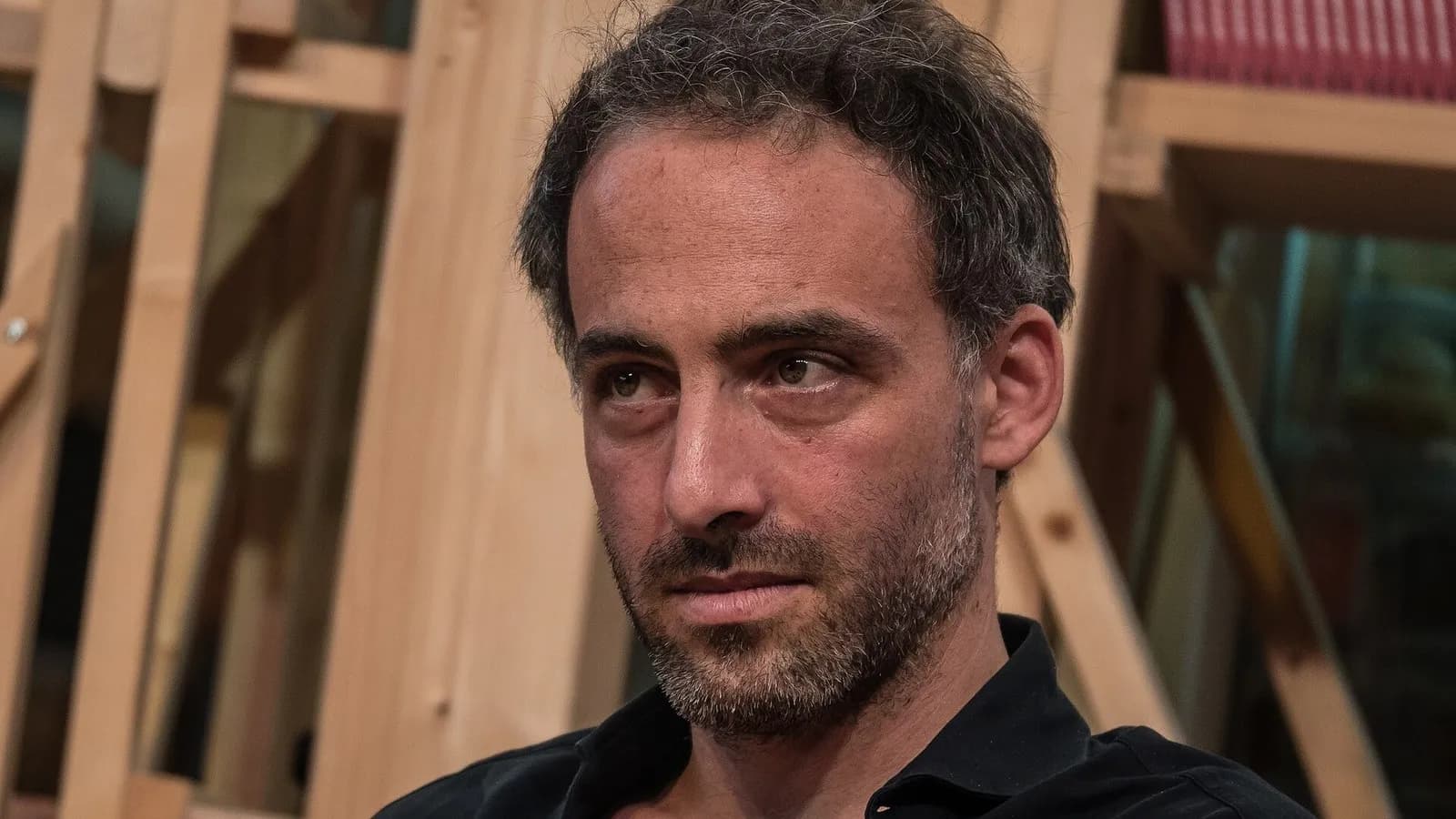 Raphael Glucksmann seated before wooden shelves, looking to one side, photographed in October 2017, a file photograph and not from the primary