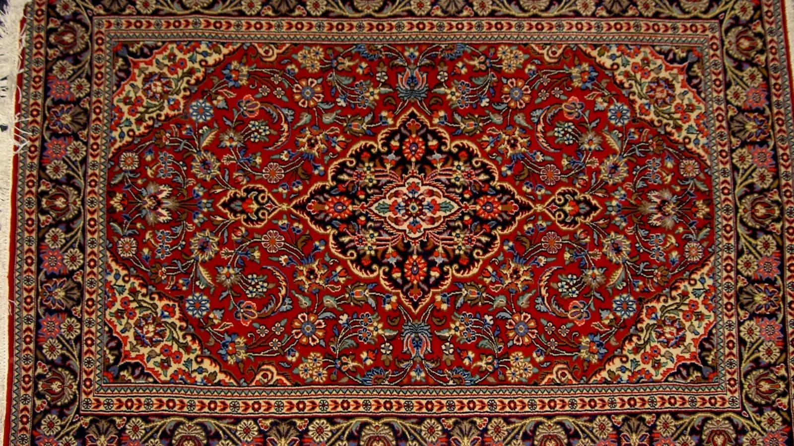The front of a hand-knotted Qom carpet from Iran with a central medallion; the article explains what the back would show
