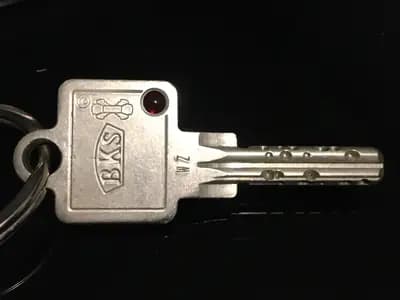 A single door key on a ring, photographed against black. A stolen session token works the same way, as a key already cut that opens the door without anyone being asked who is holding it