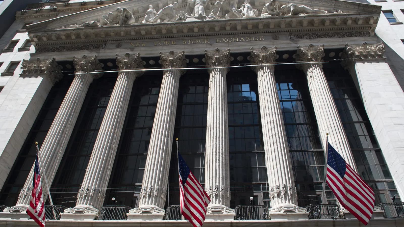 The columned facade of the New York Stock Exchange on Broad Street, hung with American flags