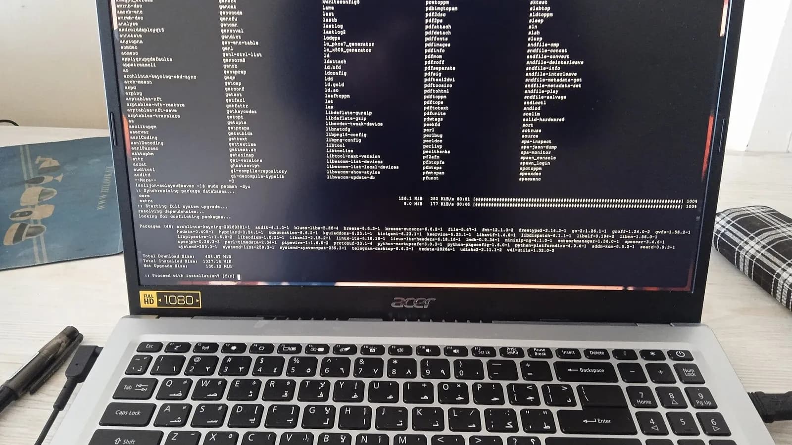 An Acer laptop showing a Linux terminal in the middle of a package update, photographed around 7 March 2026, a file photograph illustrative of updating server software and not of a PHP update