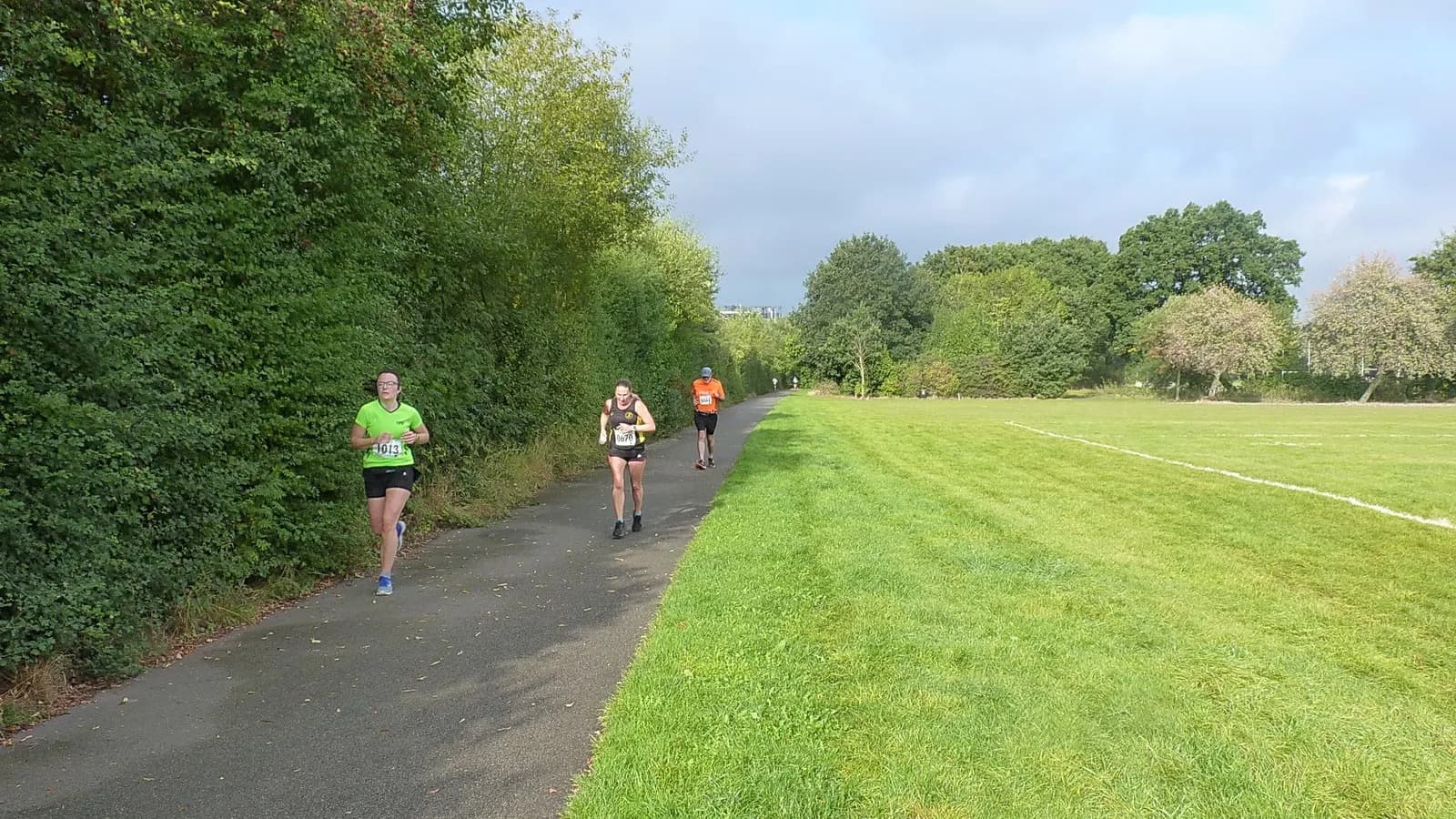 Runners on a path beside playing fields in Wigginton Park, York, in September 2021