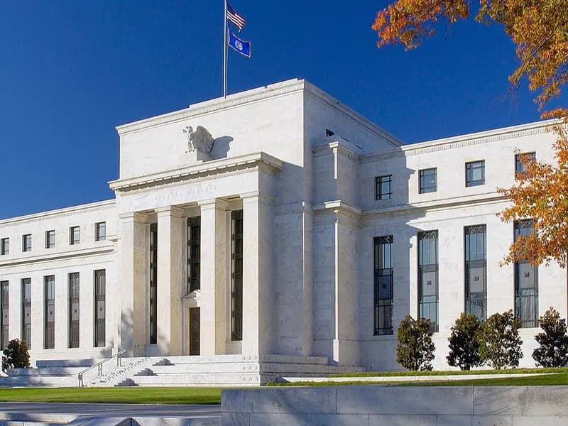 The white marble Marriner S. Eccles Federal Reserve Board Building in Washington with a flag above its portico and autumn leaves beside it, photographed on 1 September 2012, a file photograph of the central bank's headquarters and not of this week's meeting