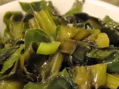 A bowl of cooked beetroot greens and their pale chopped stems, the two thirds of the bunch that most people throw away